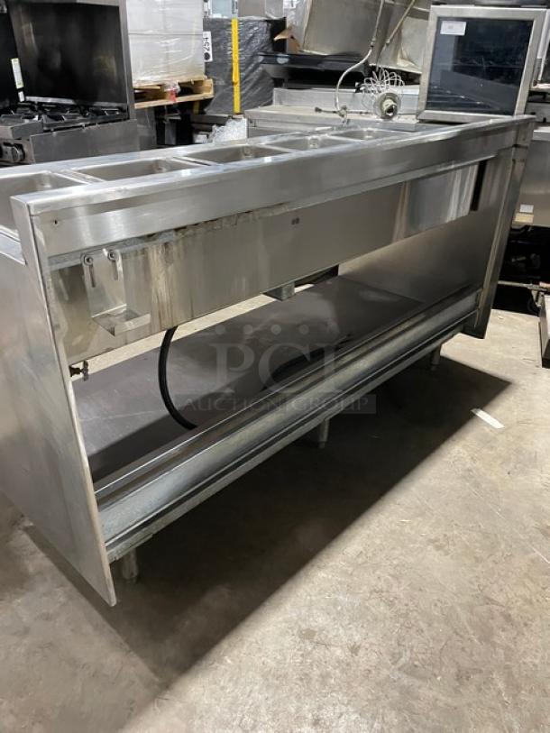 Delfield stainless steel 5-well gas steam table, heated, with lower tray slide, single undershelf, and upturned backsplash.