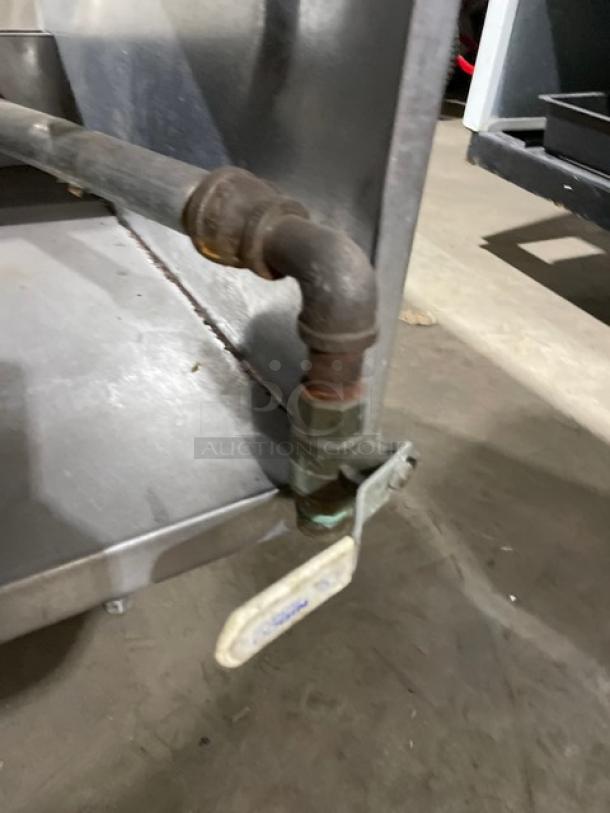 Delfield stainless steel gas-powered 5-well steam table pipe detail, industrial setting, showing connection and valve.