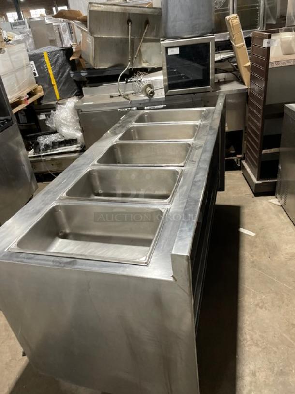 Delfield commercial stainless steel gas-powered 5-well steam table with lower tray slide, undershelf, and up-turned backsplash.