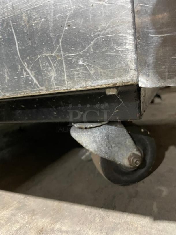 True T-23F commercial stainless steel freezer on casters, scratched surface, Energy Star certified, single door, model and serial tags visible.