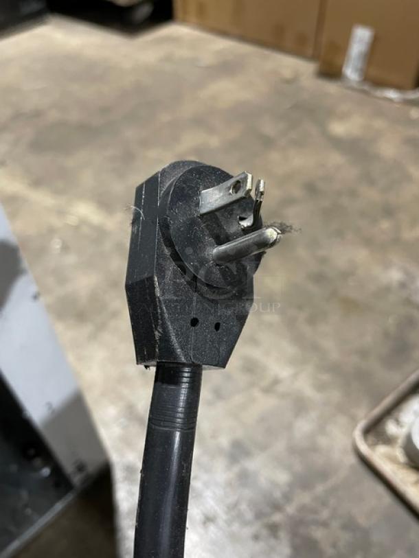 Close-up of a standard 115V power plug, slightly worn condition, part of Beverage-Air CFG241 freezer unit.