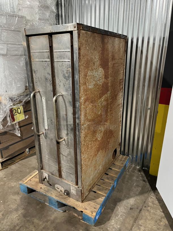 Bakers Pride stainless steel double stacked pizza deck oven on pallet. Natural gas powered. Visible wear and rust on exterior.