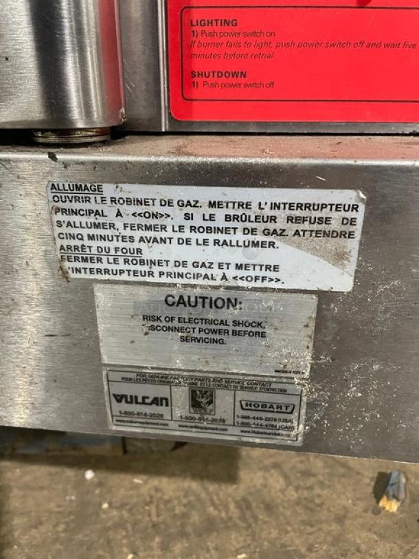 Vulcan commercial stainless steel convection oven, natural gas-powered, with wired rack. Labels show operational and safety instructions. 