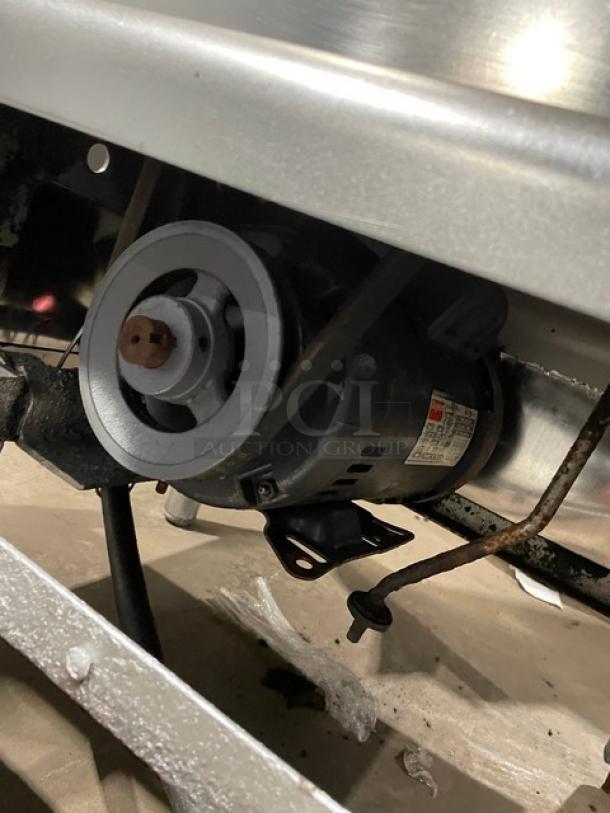 Butcher Boy commercial stainless steel electric meat band saw motor. Mounted on legs. Heavy-duty construction.