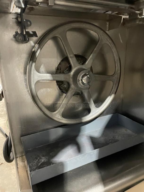 Butcher Boy stainless steel electric meat band saw, free-standing, heavy-duty design, visible pulley wheel, good condition.