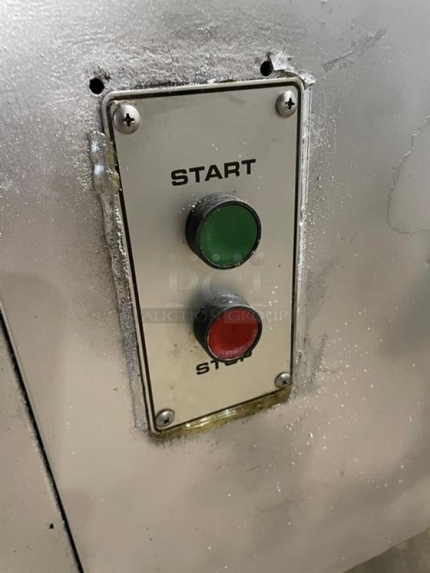 Hobart commercial meat grinder start/stop buttons on metal panel, indicating operational controls.