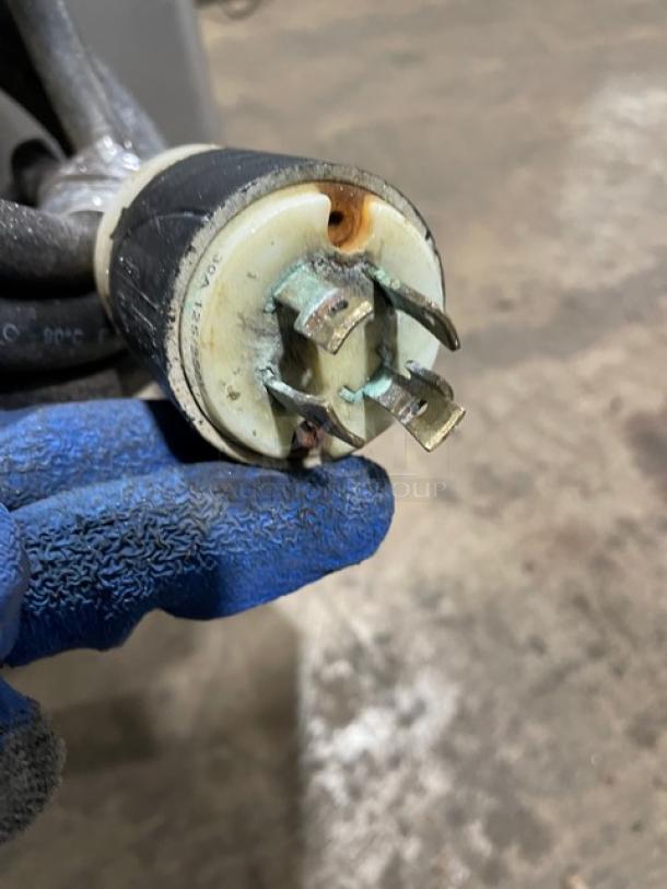 Hobart commercial meat grinder power plug with visible wear and oxidation, indicating electrical connectivity condition.