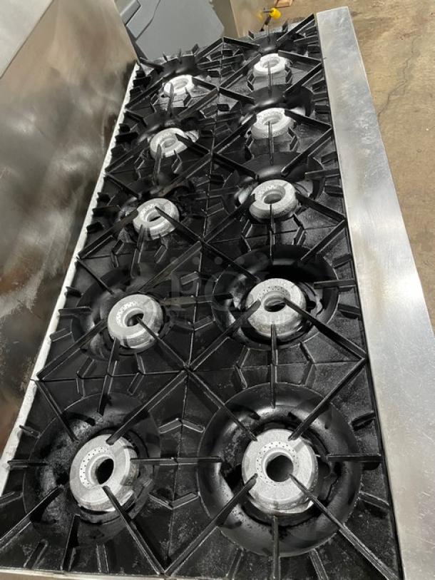 Vulcan commercial stainless steel 10-burner range with double oven, backsplash, wired rack, and salamander shelf.