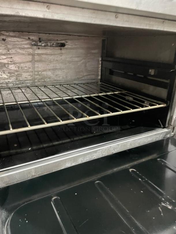 Vulcan stainless steel commercial range double oven interior view with wired rack. Features indicate natural gas operation.