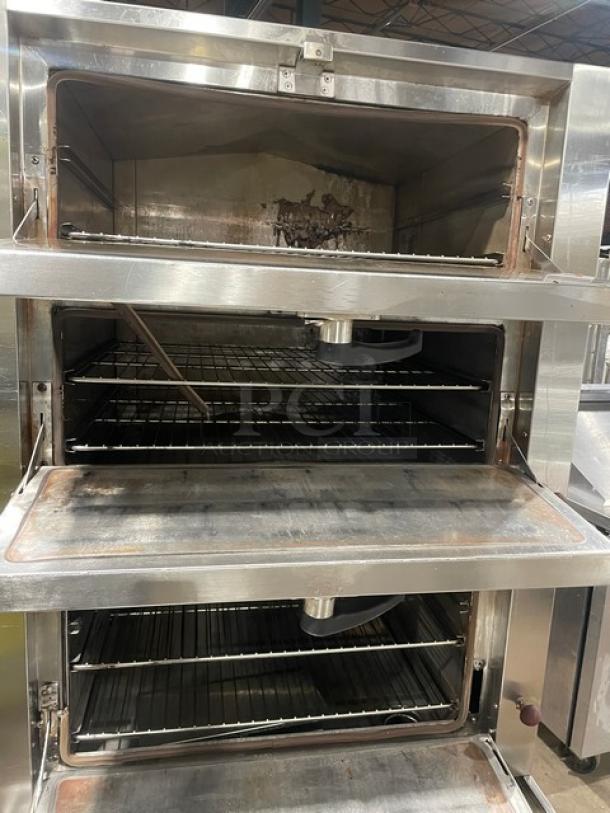 Commercial stainless steel 3-compartment seafood steamer cabinet with individual controls, wired oven rack, on legs, used condition.