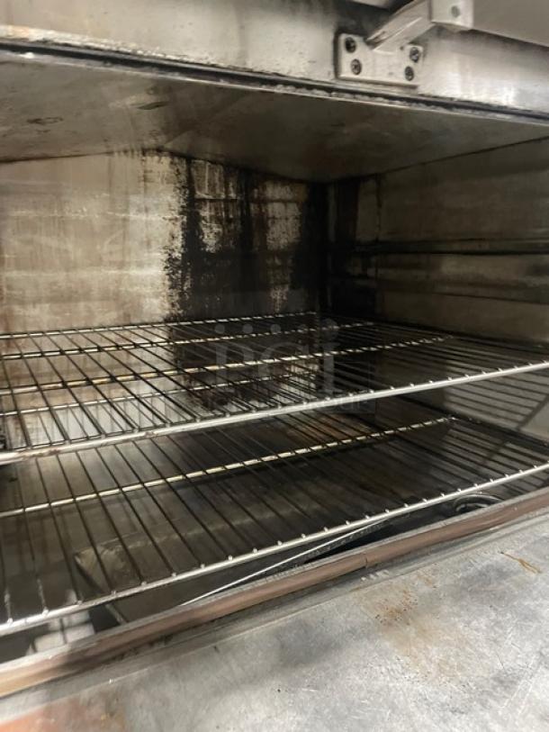 Commercial stainless steel seafood steamer cabinet with three compartments, individual controls, and wired oven racks. Mounted on legs.