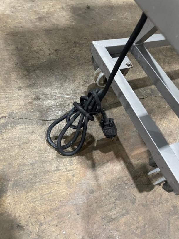 Tre Spade/Omcan MX-50 commercial meat mixing machine on metal frame with casters, electric cord coiled on ground.