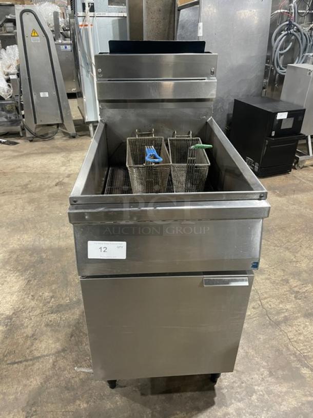 Commercial stainless steel natural gas fryer with back splash, basket hanger, and fry basket. Mounted on legs. Serial number label visible.