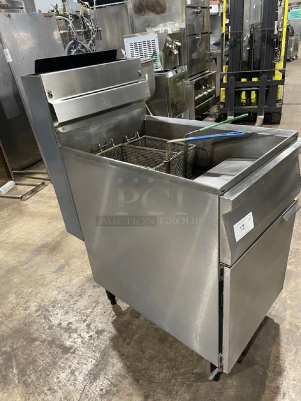 Commercial stainless steel natural gas deep fryer with backsplash, basket hanger, fry basket, and legs. Good condition.