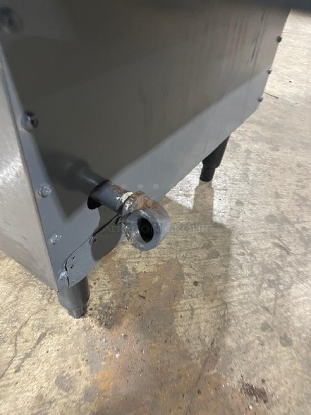 Commercial stainless steel natural gas deep fat fryer with backsplash, basket hanger, and fry basket. Mounted on legs.