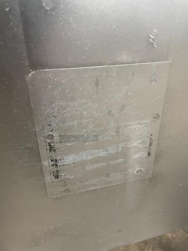 Commercial stainless steel natural gas deep fat fryer with back splash, basket hanger, and fry basket, on legs.