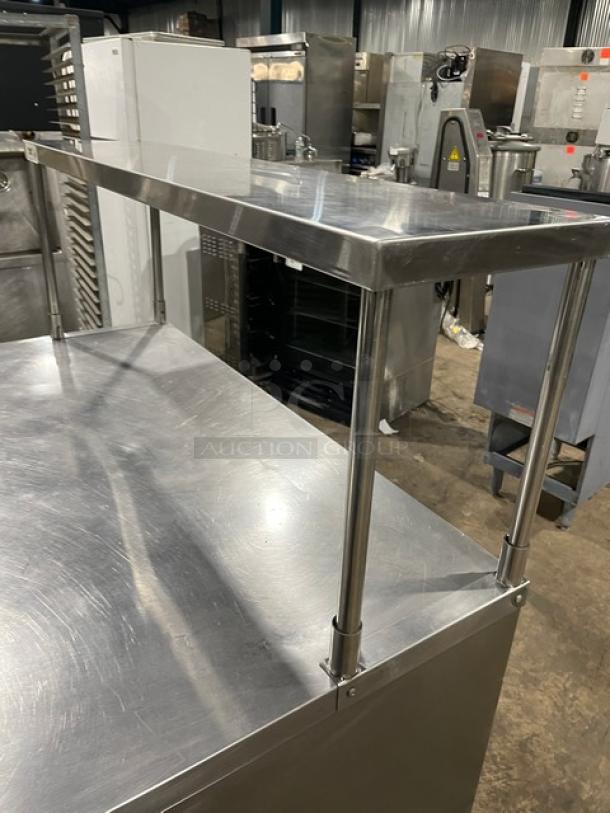 True TUC-48 stainless steel 2-door worktop refrigerator with overhead shelf, poly-coated wired rack, on casters.