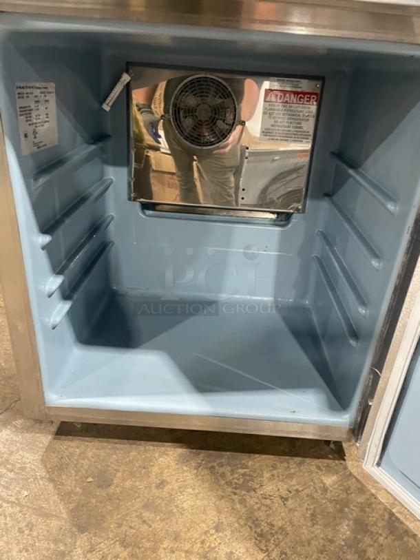 Delfield stainless steel undercounter refrigerator, model 406PSTAR2. Interior view shows fan, tags, and adjustable shelves.