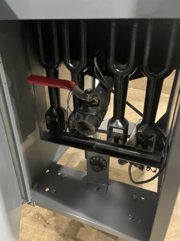 Cookline commercial stainless steel gas fryer, features back splash, fry basket, on legs; viewed from the burner area.