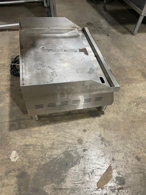 Avantco 177EG24N stainless steel countertop flat griddle with back and side splash, electric powered, on legs, 208/240V.