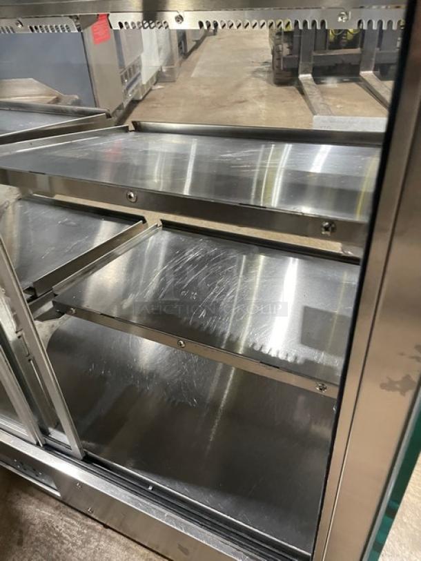 Stainless steel electric countertop food merchandiser display case with rear double glass sliding doors, multi-level shelves.
