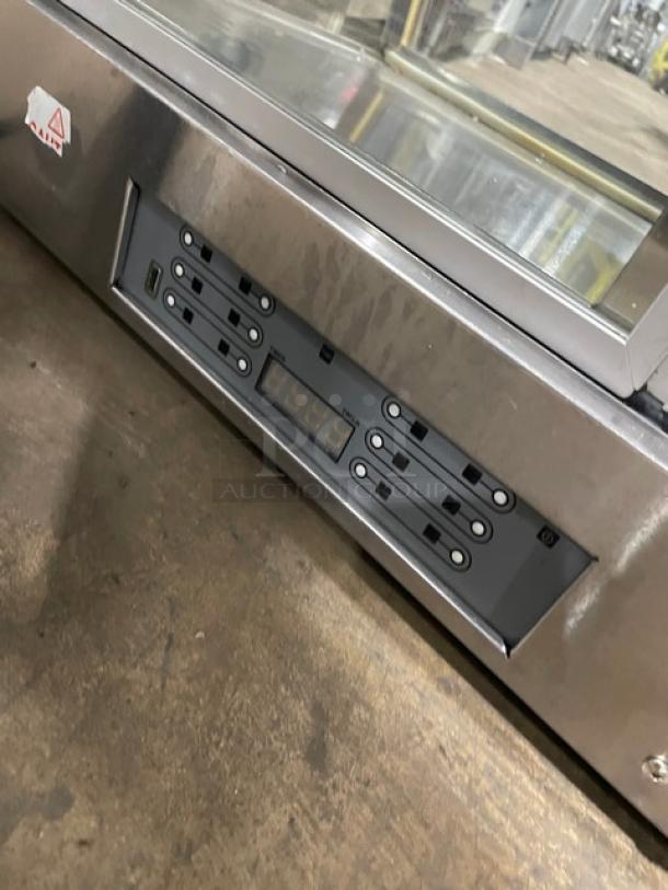 Commercial stainless steel electric countertop food display case with multi-level heating, rear glass doors.