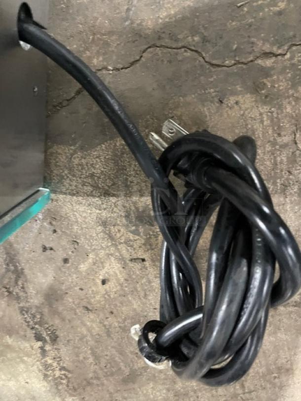 Stainless steel electric heated food display case with coiled power cord, rear double glass sliding doors, countertop model.