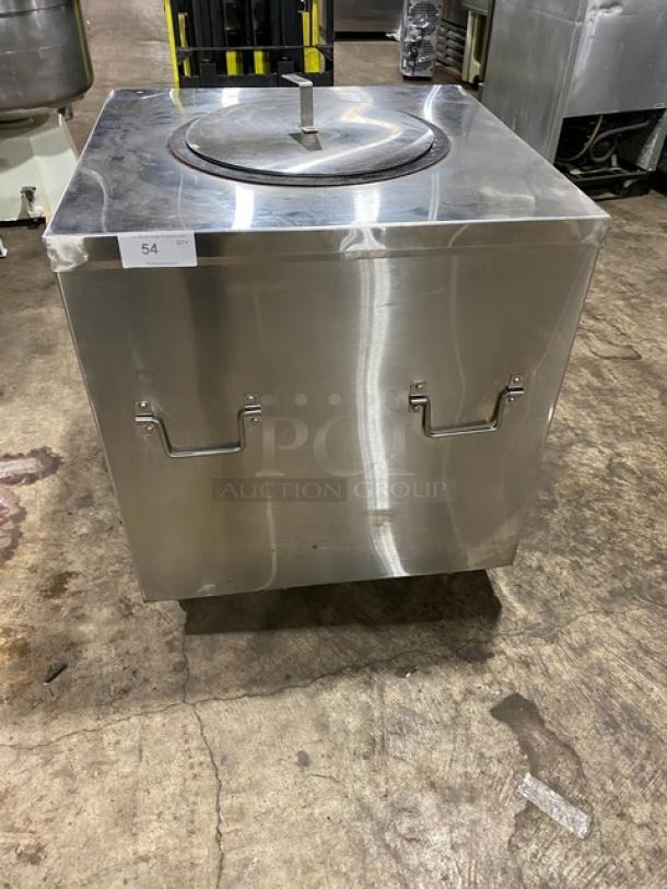 Commercial stainless steel natural gas powered tandoor oven on casters. Features durable handles. Good condition.