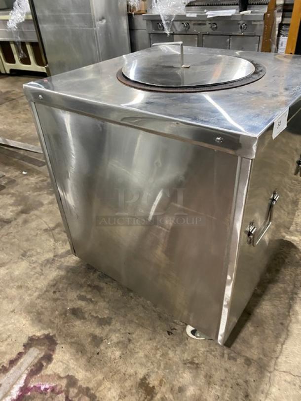 Commercial stainless steel tandoor oven, natural gas powered, on casters. Features include robust handles and metal lid, in used condition.