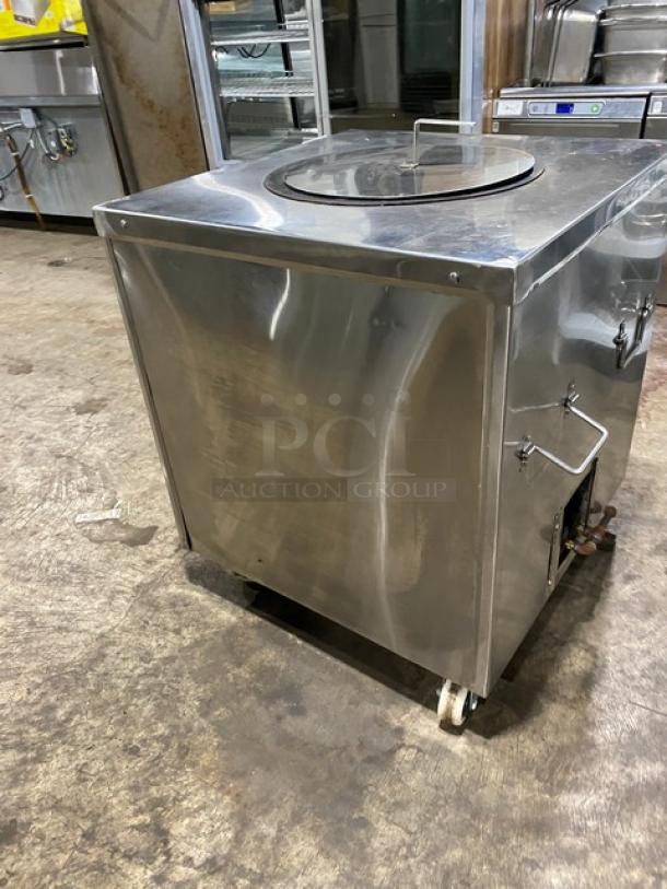 Commercial stainless steel natural gas tandoor oven on casters, used, with top lid handle. Ideal for restaurants.
