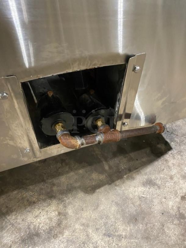 Commercial stainless steel natural gas tandoor oven on casters, showing gas connections. Used condition.