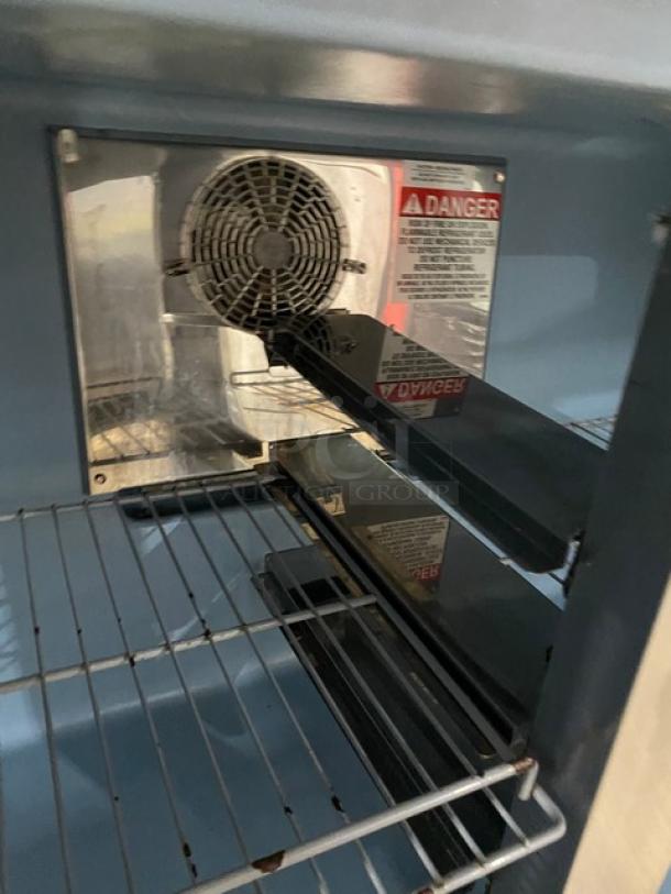 Delfield UC4048P-STAR undercounter worktop refrigerator interior with coated wire rack, visible fan, and safety label.