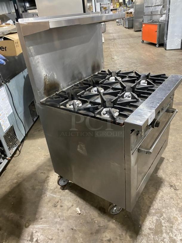 SunFire commercial stainless steel 6-burner range/oven combo with backsplash, overhead salamander shelf, and wired oven rack on casters.