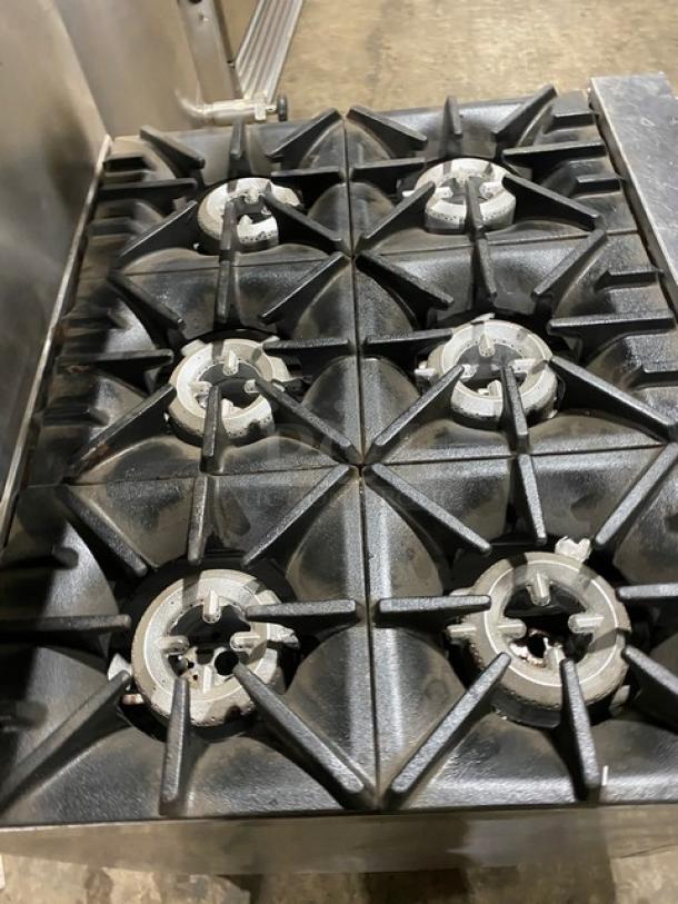 SunFire stainless steel 6-burner natural gas range/oven combo with backsplash, overhead salamander shelf, and casters.