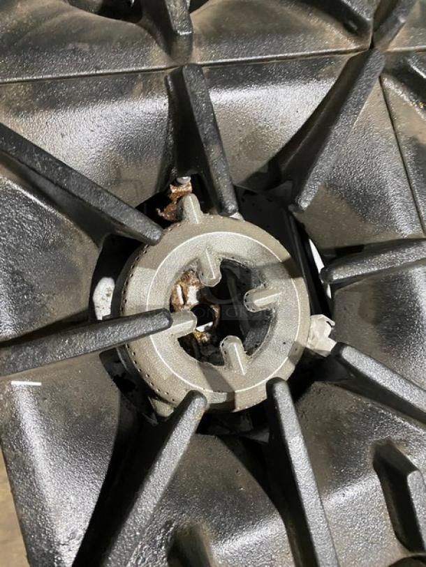 SunFire commercial stainless steel natural gas burner, part of 6-burner range/oven combo, showing cast iron grate detail.