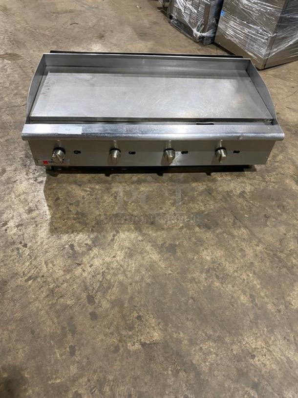 Cecilware Pro stainless steel natural gas countertop flat griddle with back and side splash, on legs. Four control knobs.