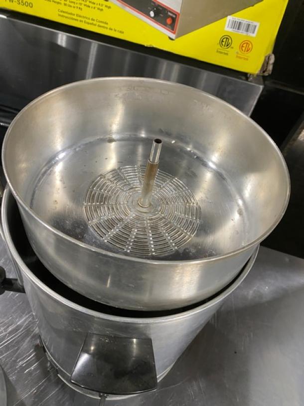 Commercial stainless steel electric coffee urn, insulated, in good condition. Features sturdy handles and a secure lid.