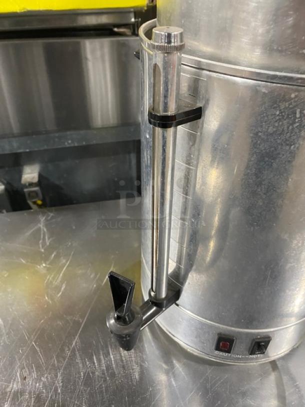 Commercial stainless steel electric coffee urn, insulated, with spigot and control buttons. Appears in good condition.