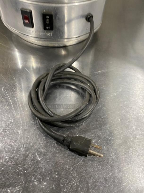 Commercial stainless steel electric coffee urn with plug, power switch, and light indicator; insulated and durable condition.