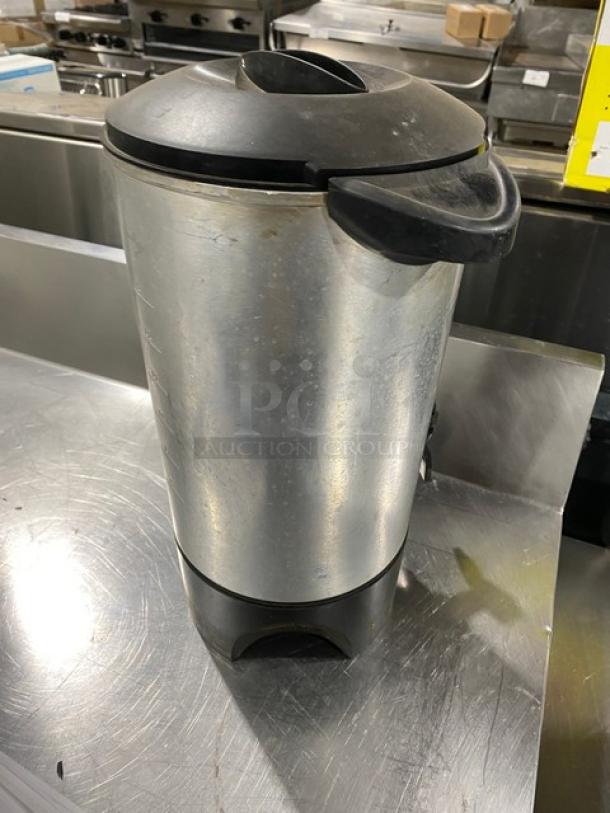 Stainless steel electric insulated coffee urn, commercial grade, in used condition. Features a black handle and lid.