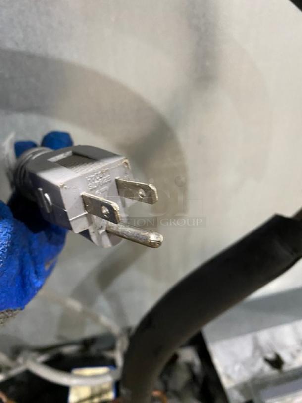 Close-up of a three-prong electrical plug for a Duke RUF48M refrigerated worktop. Features a grey plug with visible prongs.