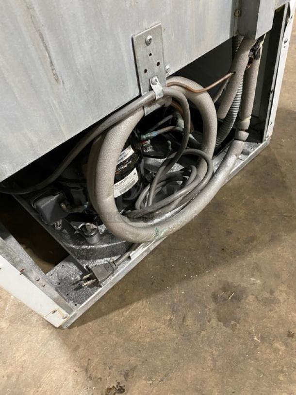 Turbo Air TGM-14RV commercial refrigerator back view, showing wiring and compressor, model label visible.