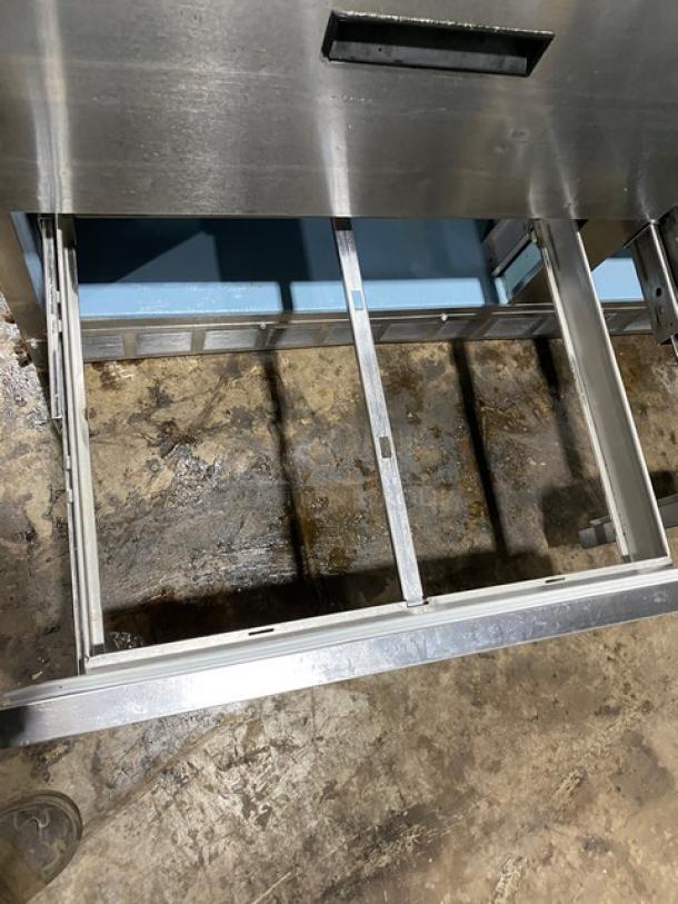 Commercial stainless steel 4-drawer refrigerated prep table with Bain Marie style, enclosed overhead shelf, and cutting board.