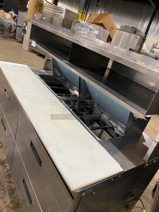 Commercial stainless steel 4-drawer refrigerated Bain Marie prep table with enclosed overhead shelf and cutting board.