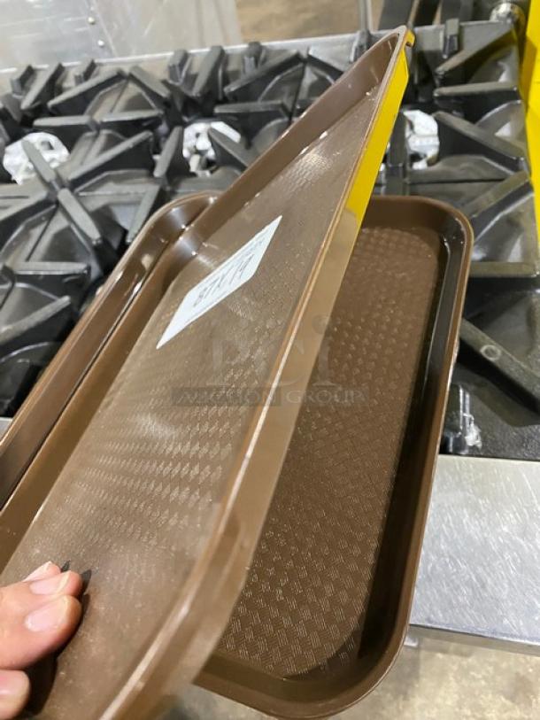 Cambro 1418FF167 brown rectangular serving tray, commercial-grade, textured surface, shown on a stove, with label indicating model.