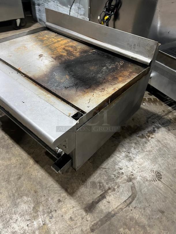 Imperial RG36 stainless steel 36" flat griddle, natural gas, with broiler, upturned back splash, and legs. Visible signs of use.