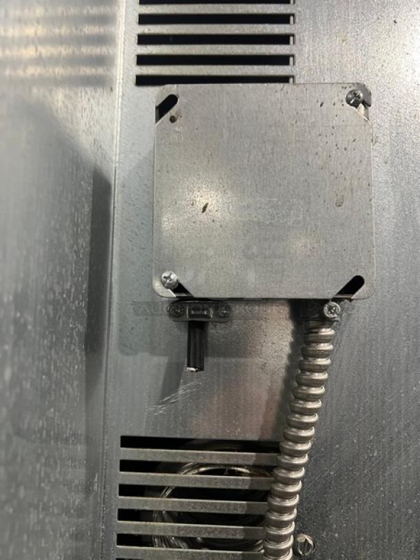 Imperial commercial stainless steel convection oven detail, featuring metal casing and wiring. Natural gas powered.