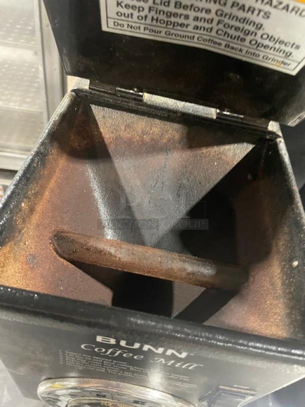 Bunn Coffee Mill Series G1HD black electric espresso grinder, 120V, commercial use, visible wear, open top showing interior.