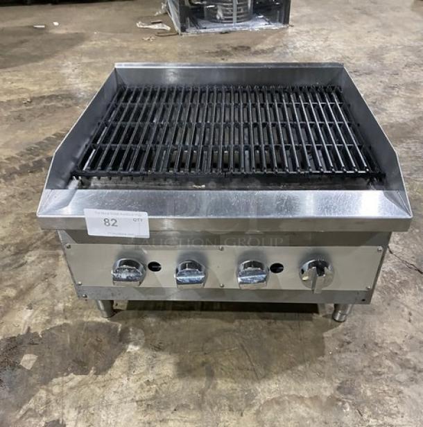 Commercial stainless steel gas countertop char broiler, wavy grates, on legs, four control knobs, used condition, tag labeled "82 QTY."