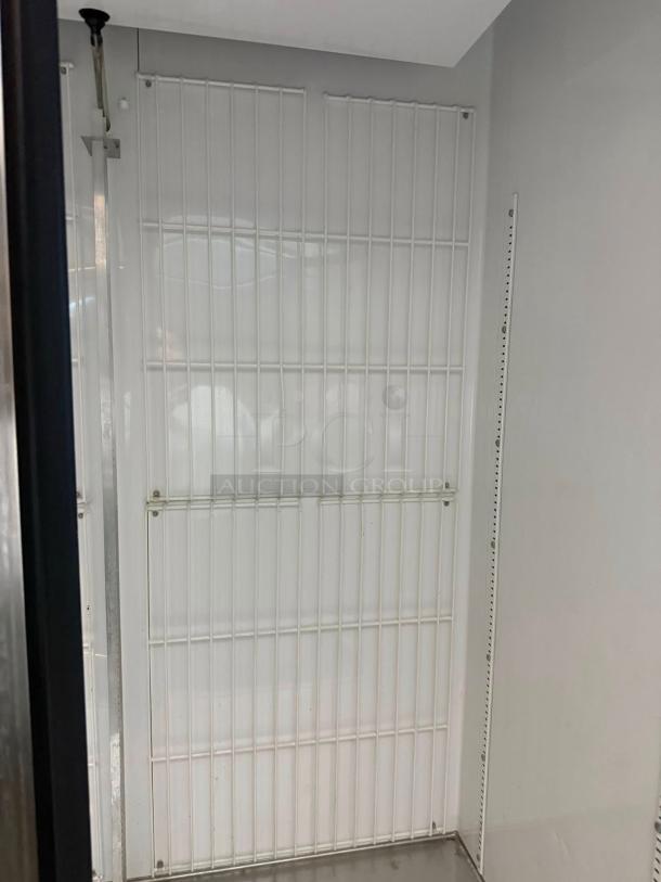 True GDM-49F-LD double door glass freezer interior showing clean, white shelving in outstanding condition.
